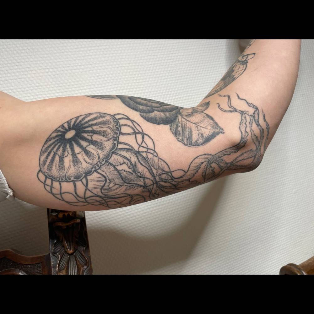 Jellyfish tattoo in blackwork style located on the inner arm.