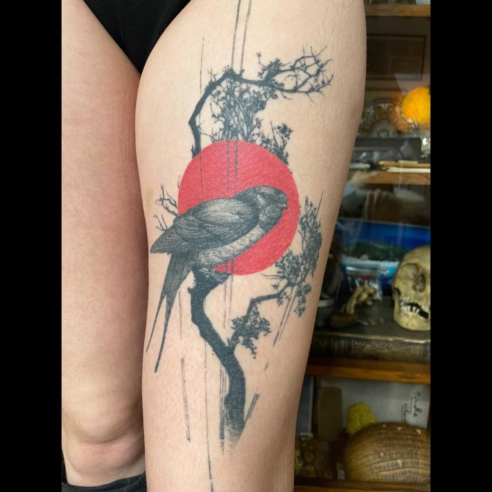 Graphic style swallow tattoo located on the thigh.