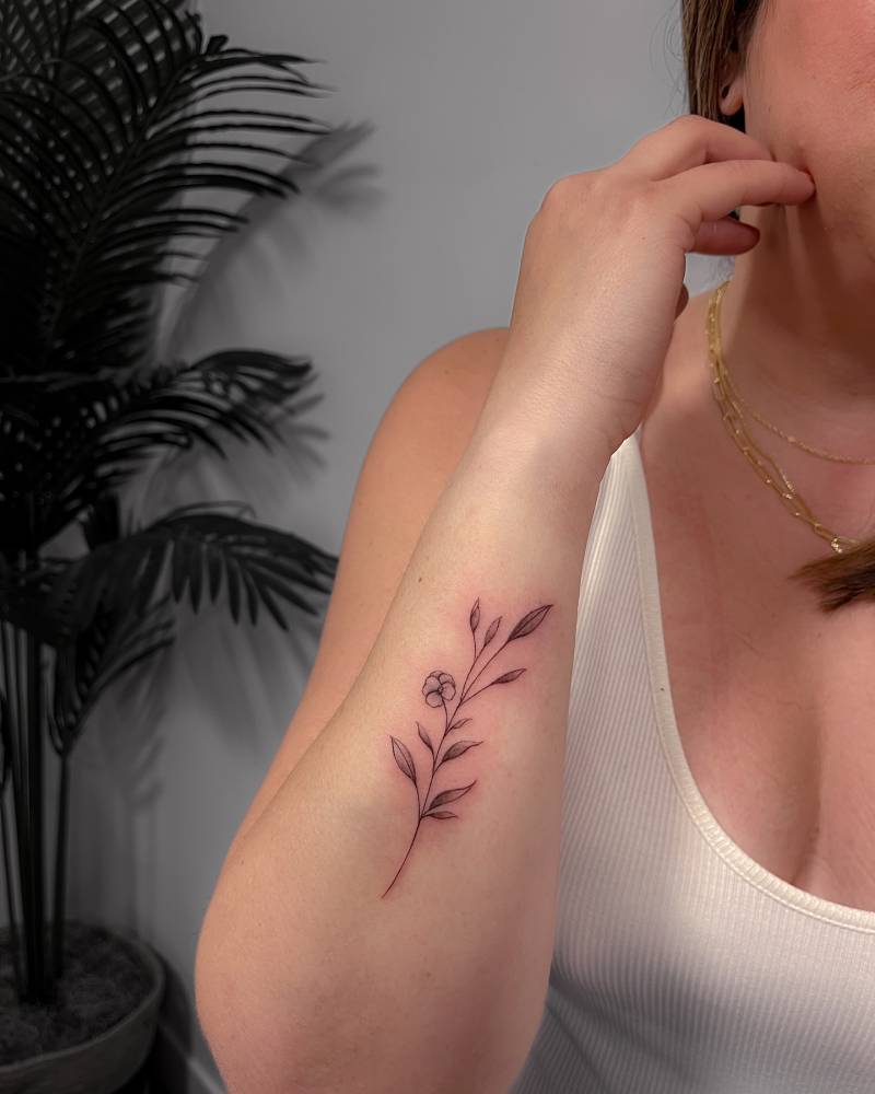 Flower tattoo in illustrative style located on the forearm.