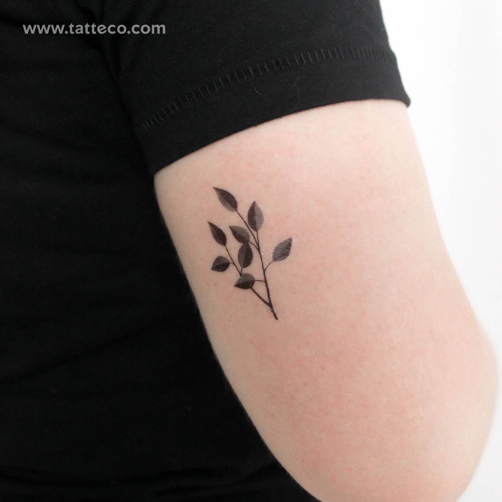 Watercolor style grey leaves temporary tattoo located on the tricep.