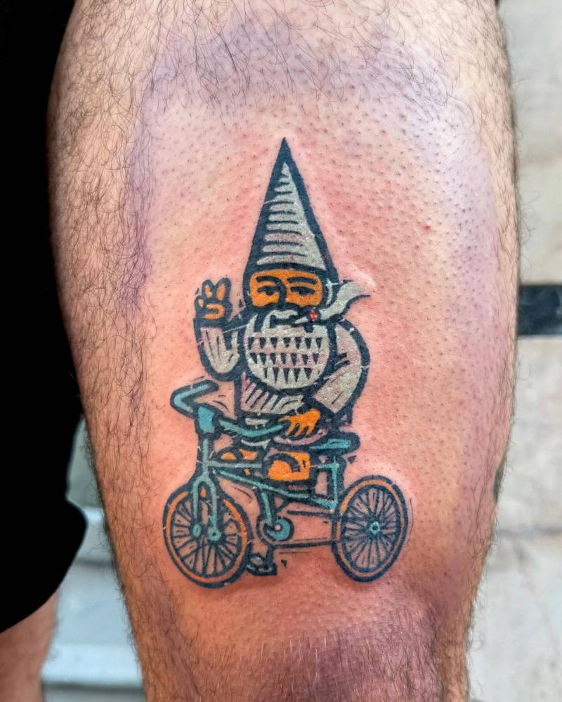Cycling gnome tattoo located on the thigh, pop art style.