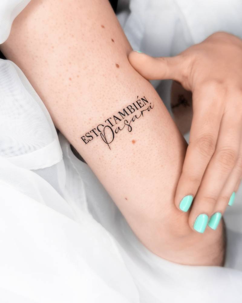 "Esto también pasará" lettering tattoo located on the tricep.