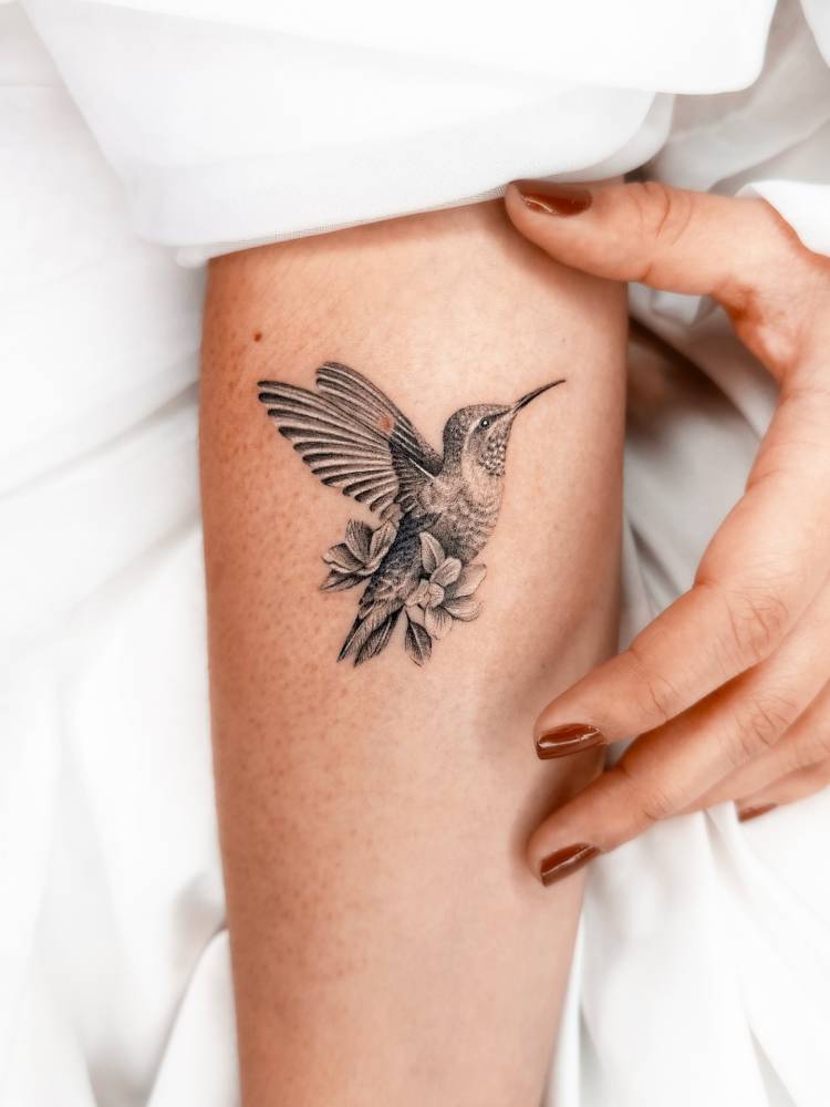 Hummingbird tattoo in micro-realistic style placed on the inner forearm.