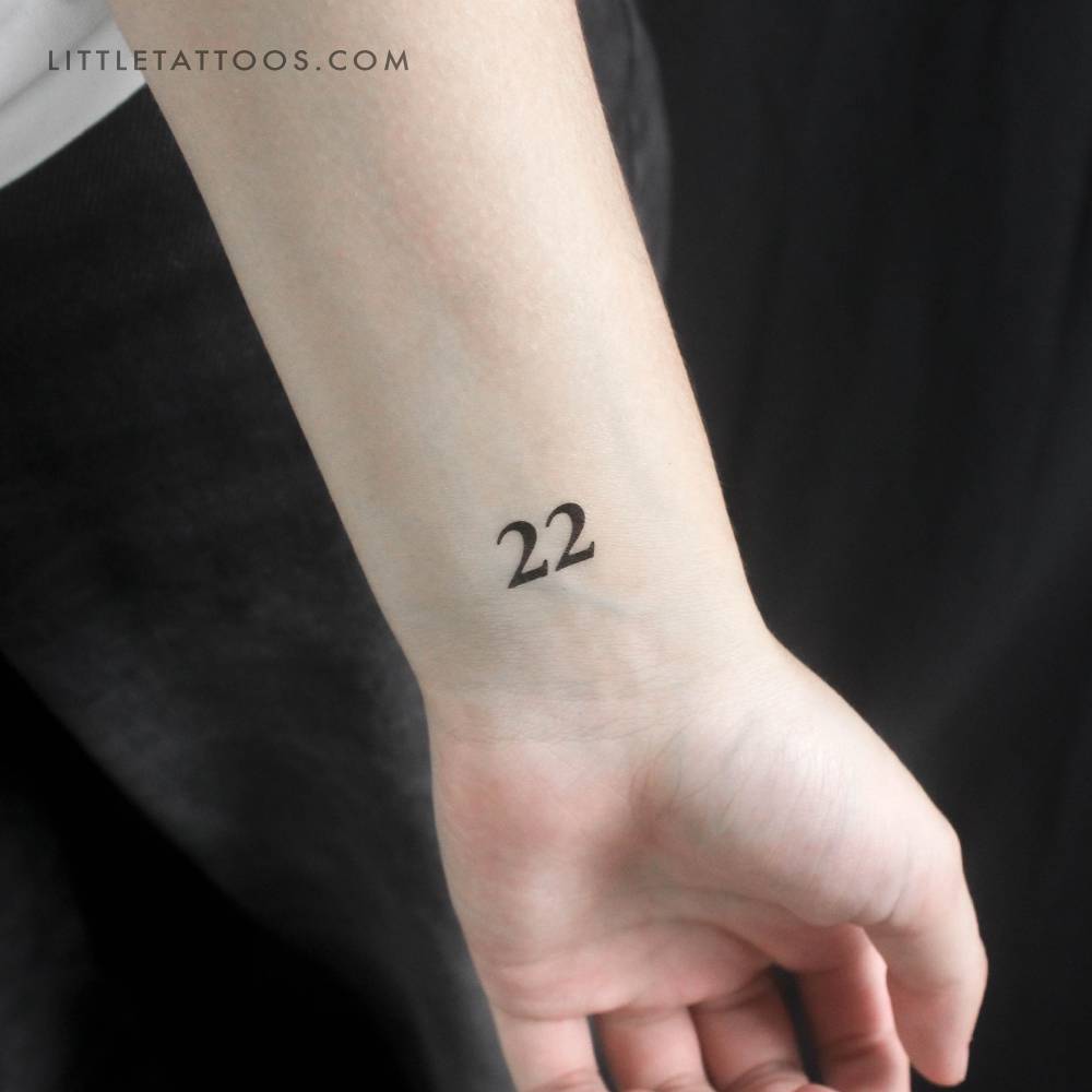 Tiny number "22" temporary tattoo located on the wrist.
