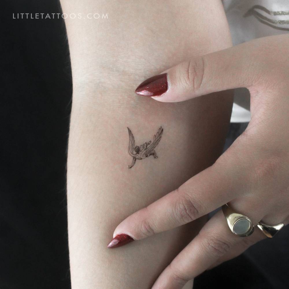 Small falling angel temporary tattoo located on the inner forearm.