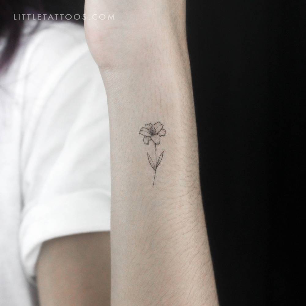Fine line style lily flower temporary tattoo located on the wrist.