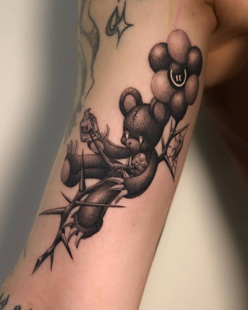 Teddy bear tattoo located on the inner arm, done in cartoon style.