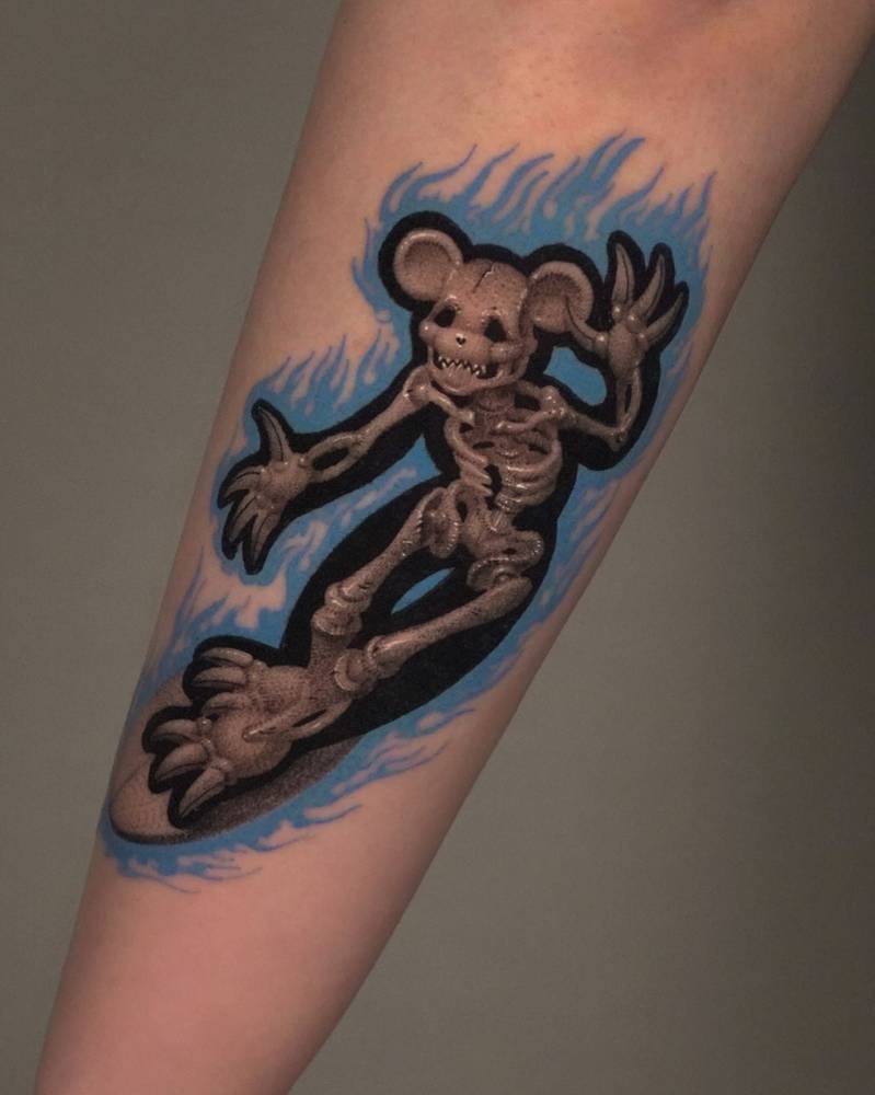 Pop art style x-ray surfing mouse tattoo located on the forearm.