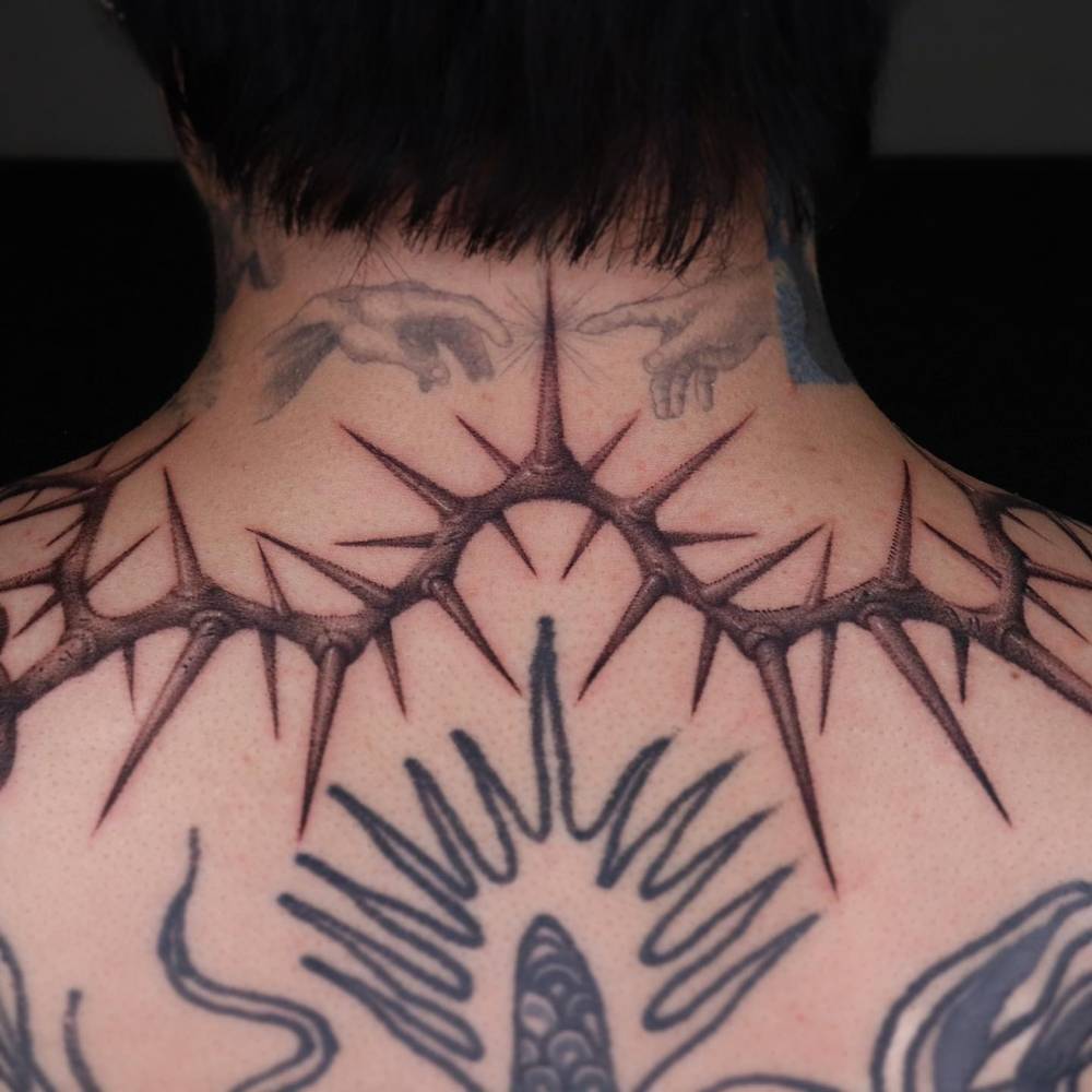 Thorns tattoo in dotwork style located on the upper back.