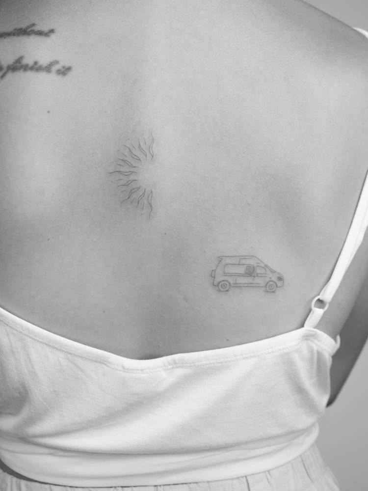 Fine line style sun and van tattoo located on the back.