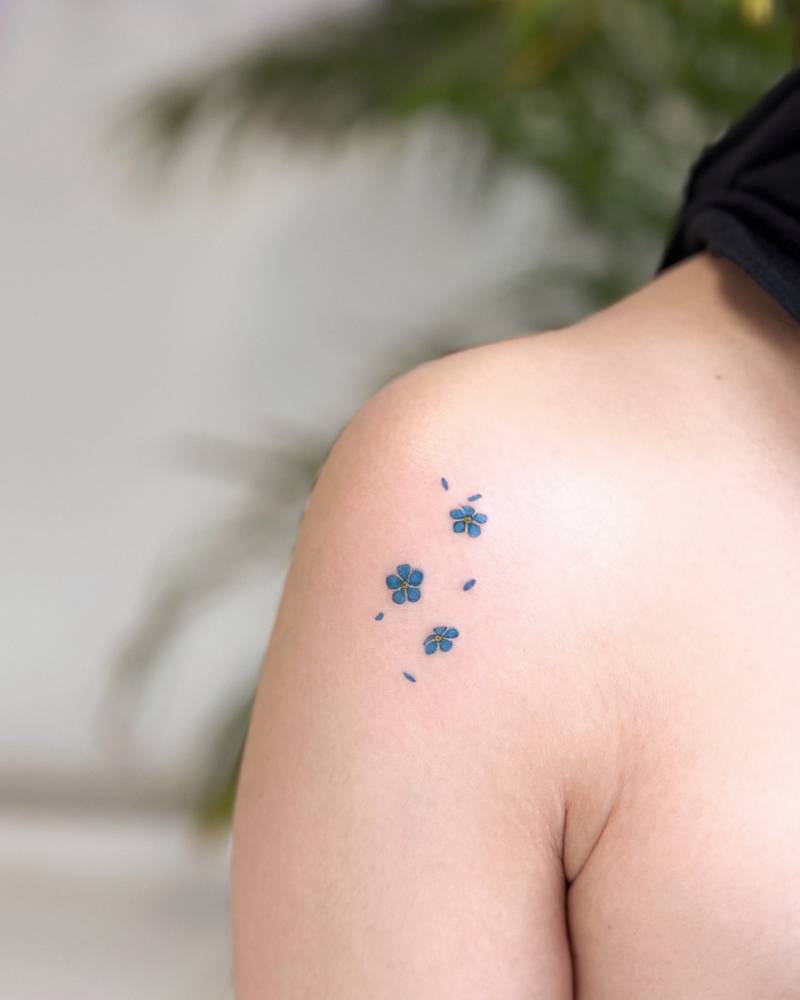 Tiny forget-me-not tattoo located on the shoulder.