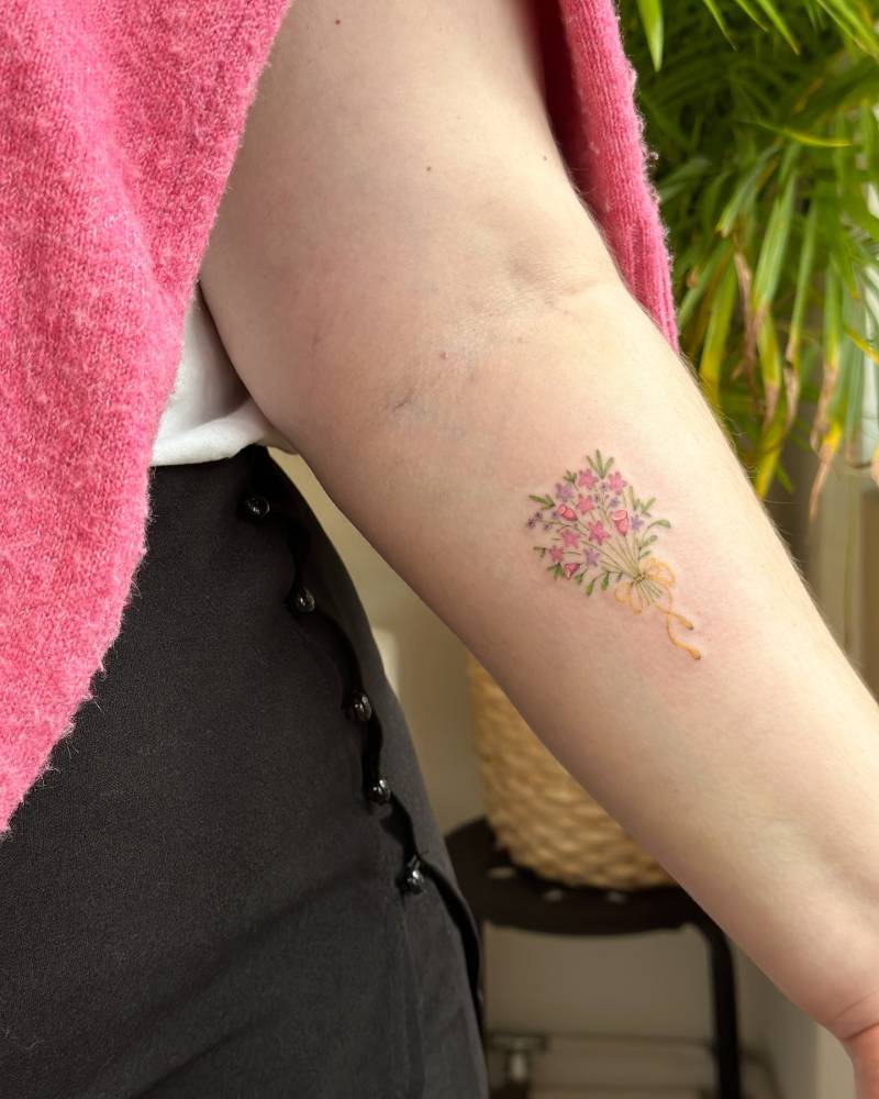 Watercolor style flower bouquet tattoo located on the inner forearm.