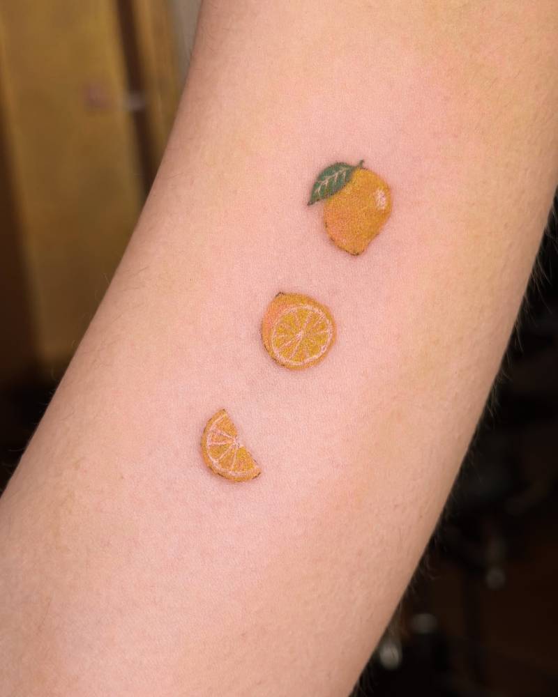 Watercolor style lemons tattooed on the inner arm.