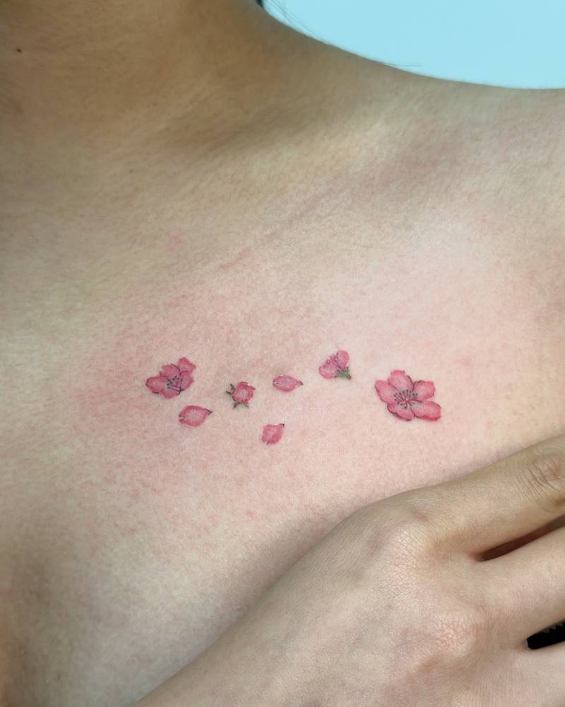 Cherry blossom tattoo in watercolor style placed on the chest.