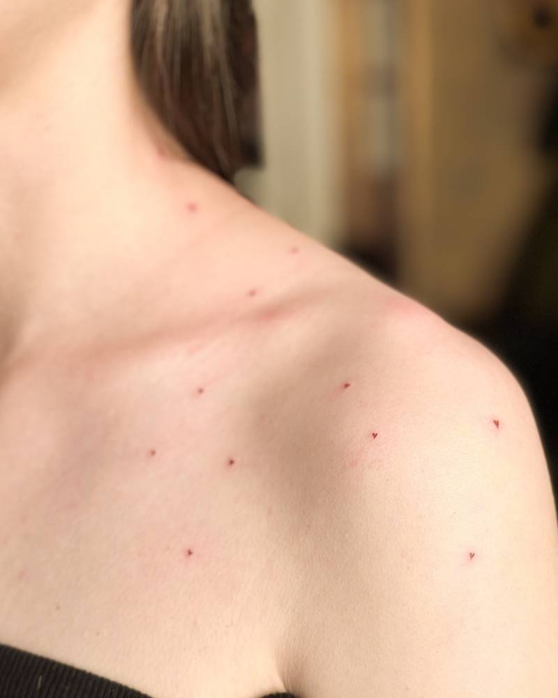 Heart freckles tattoo located on the shoulder.