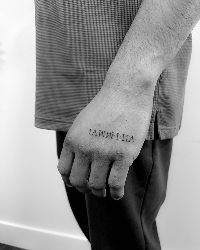 Date in roman numerals tattooed on the hand.