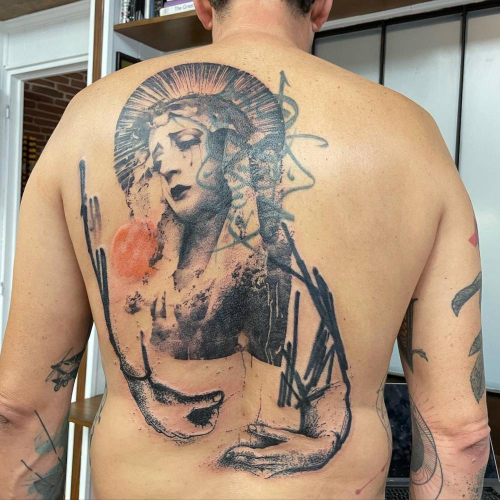 Graphic style Virgin Mary tattoo located on the back.