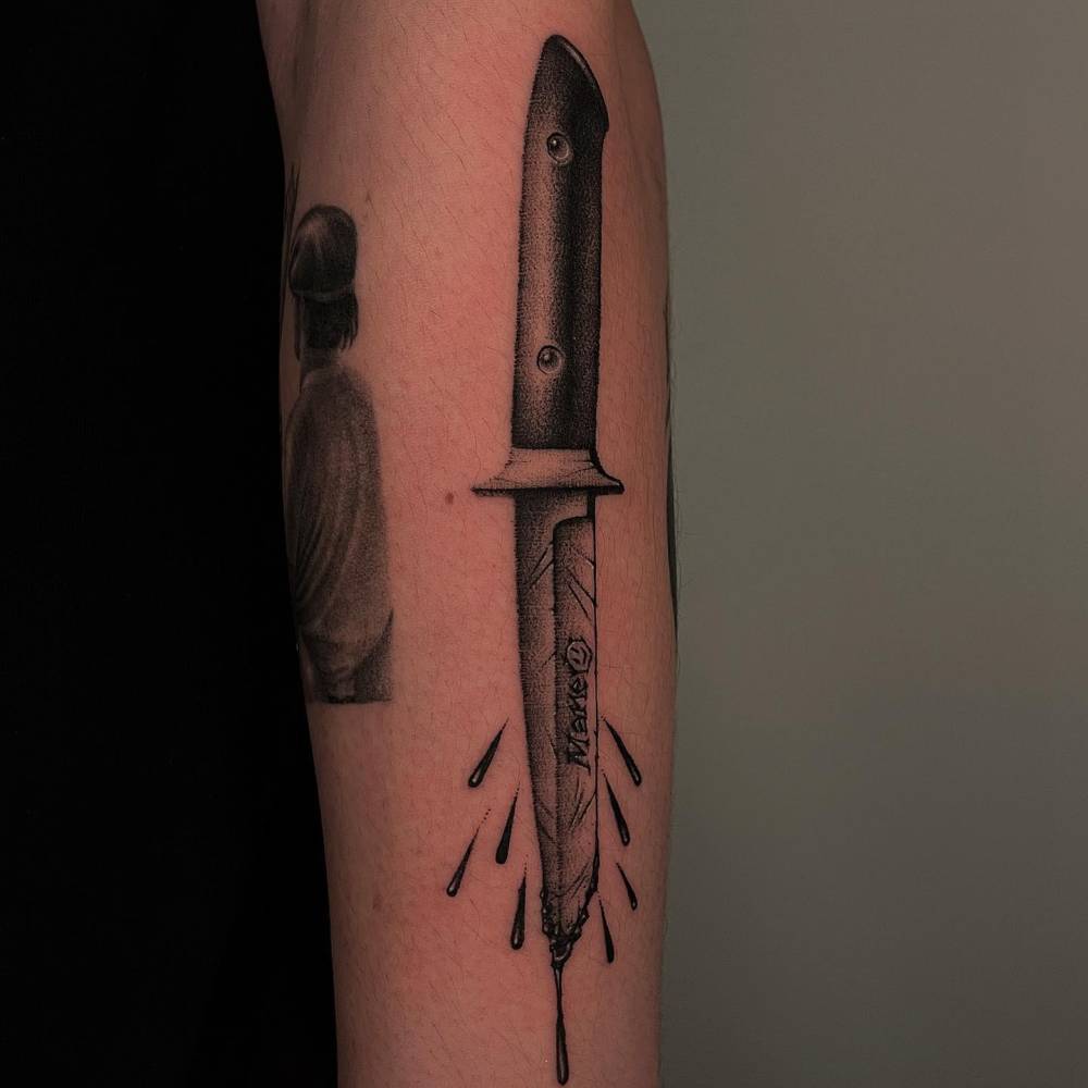 Knife tattoo located on the forearm, blackwork style.
