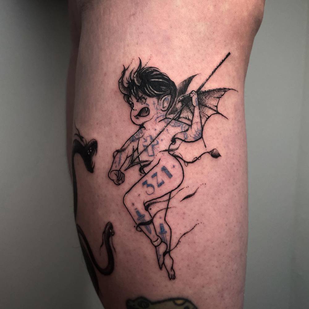 Devil tattoo located on the calf, cartoon style.