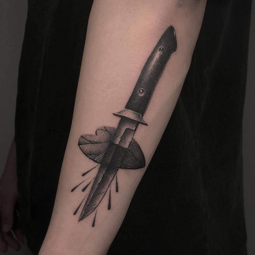 Heart and dagger tattoo in dotwork style located on the forearm.