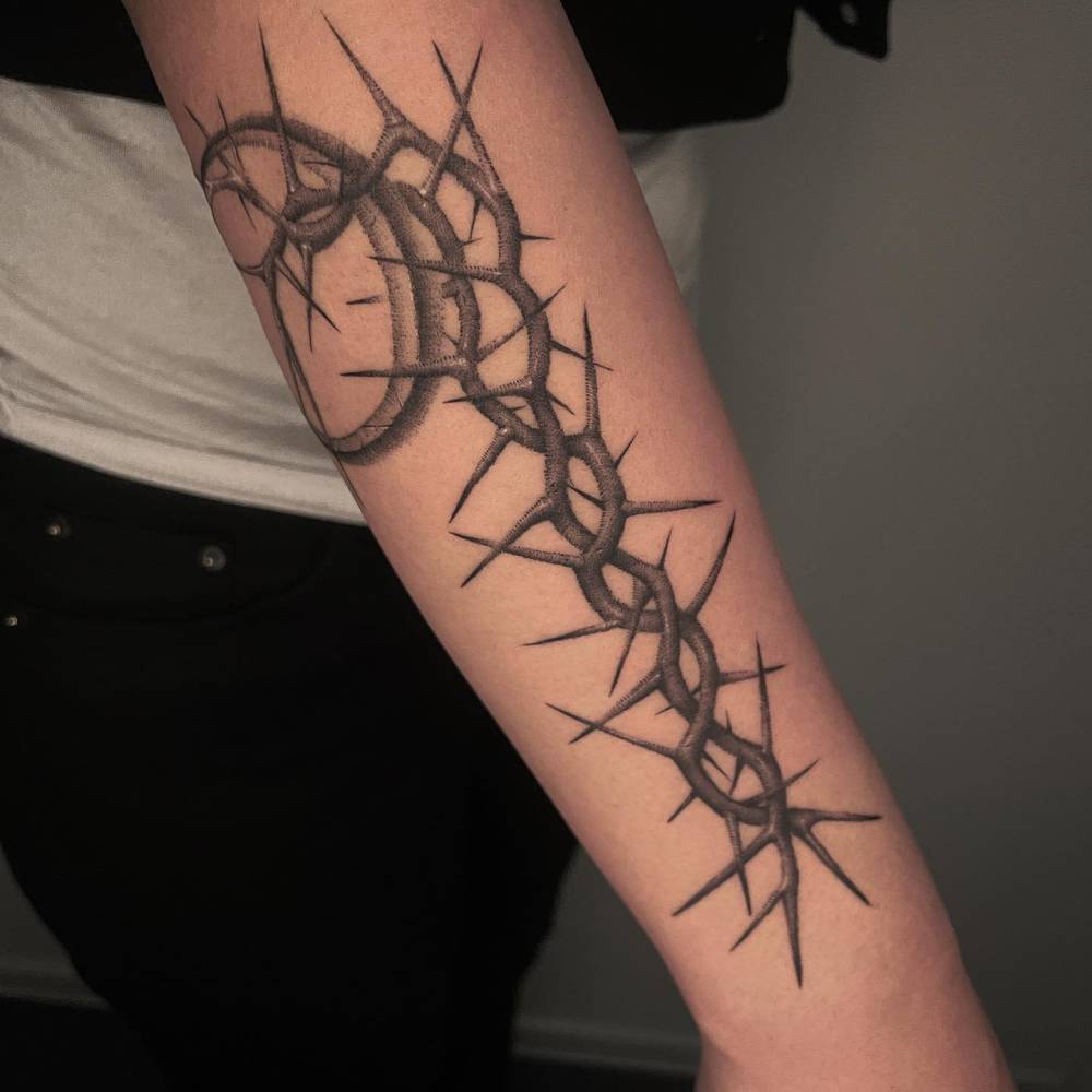 Dotwork style thorns tattoo located on the forearm.