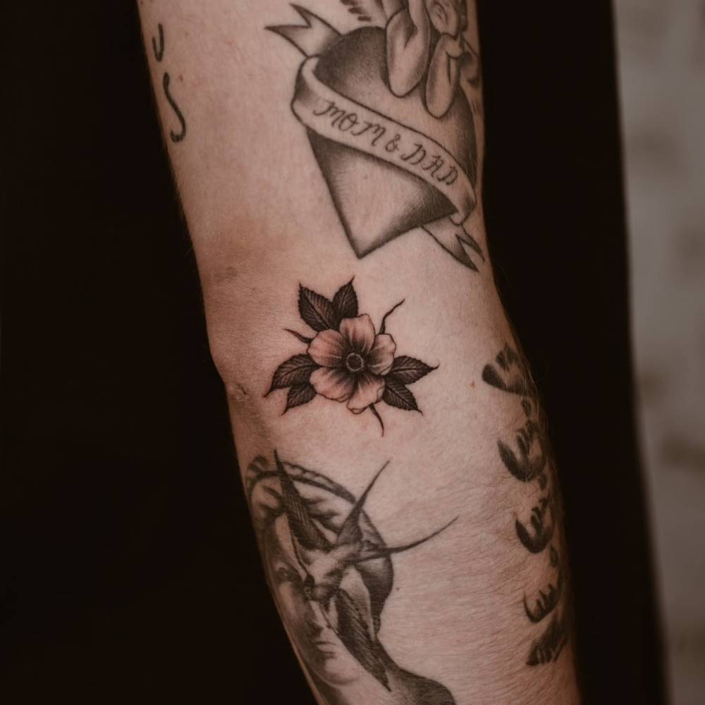 Illustrative style flower tattoo done on the elbow.
