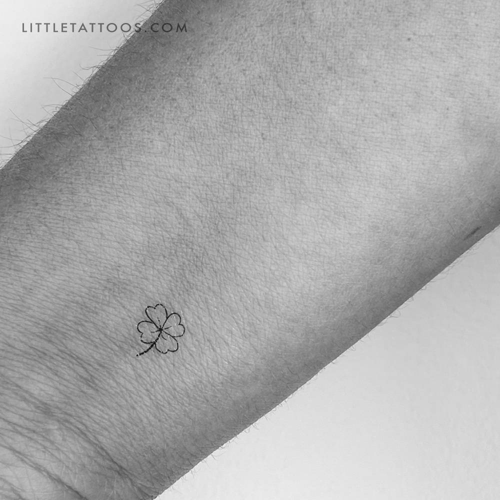 Fine line style tiny four leaf clover temporary tattoo located on the wrist.