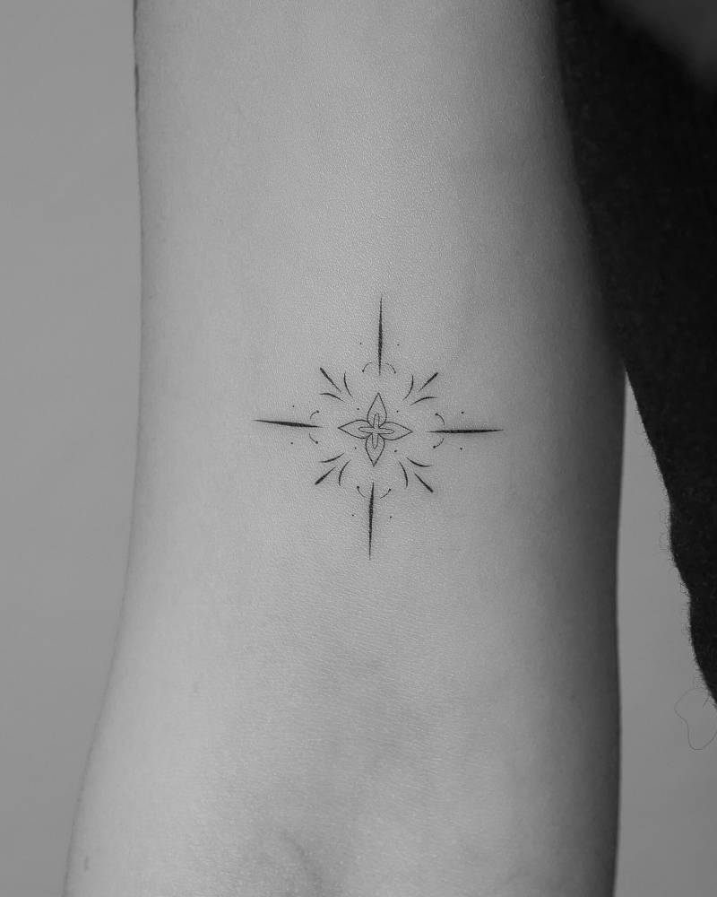 Ornamental tattoo in fine line style located on the bicep.