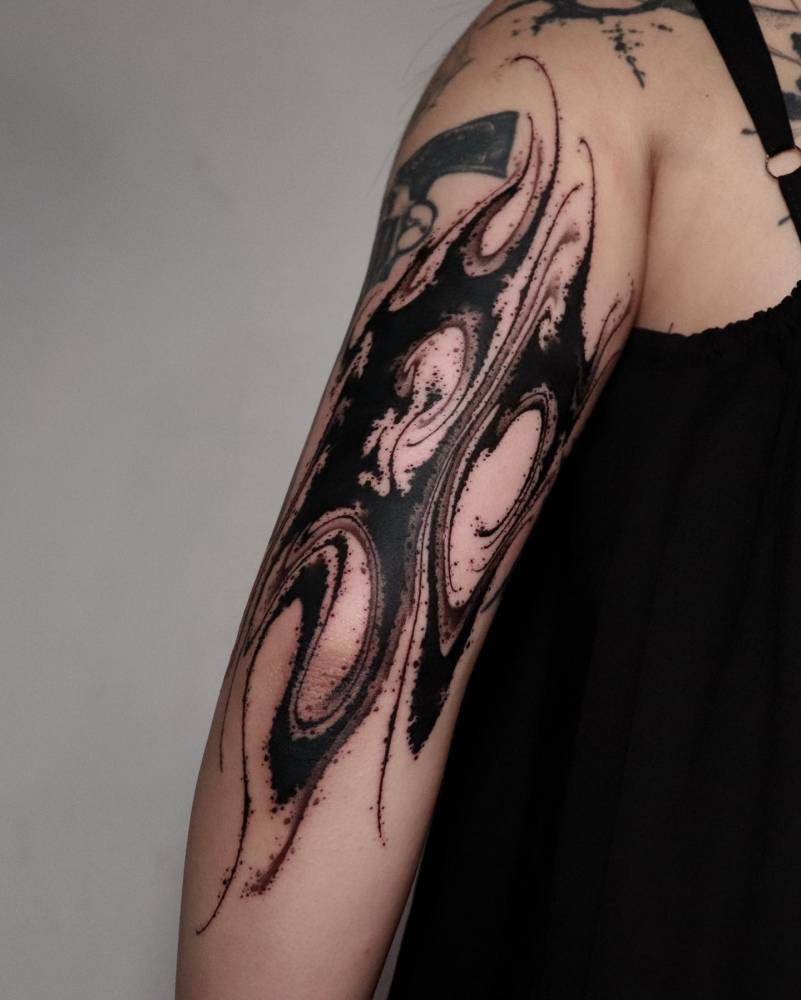 Blackwork style abstract design tattooed on the tricep.