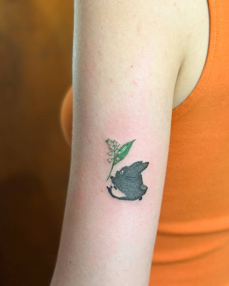 Cartoon style Chuu Totoro tattoo located on the upper arm.