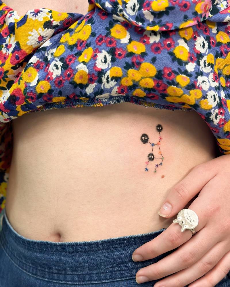 Cartoon style Soot Sprite and Virgo constellation tattoo done on the rib.
