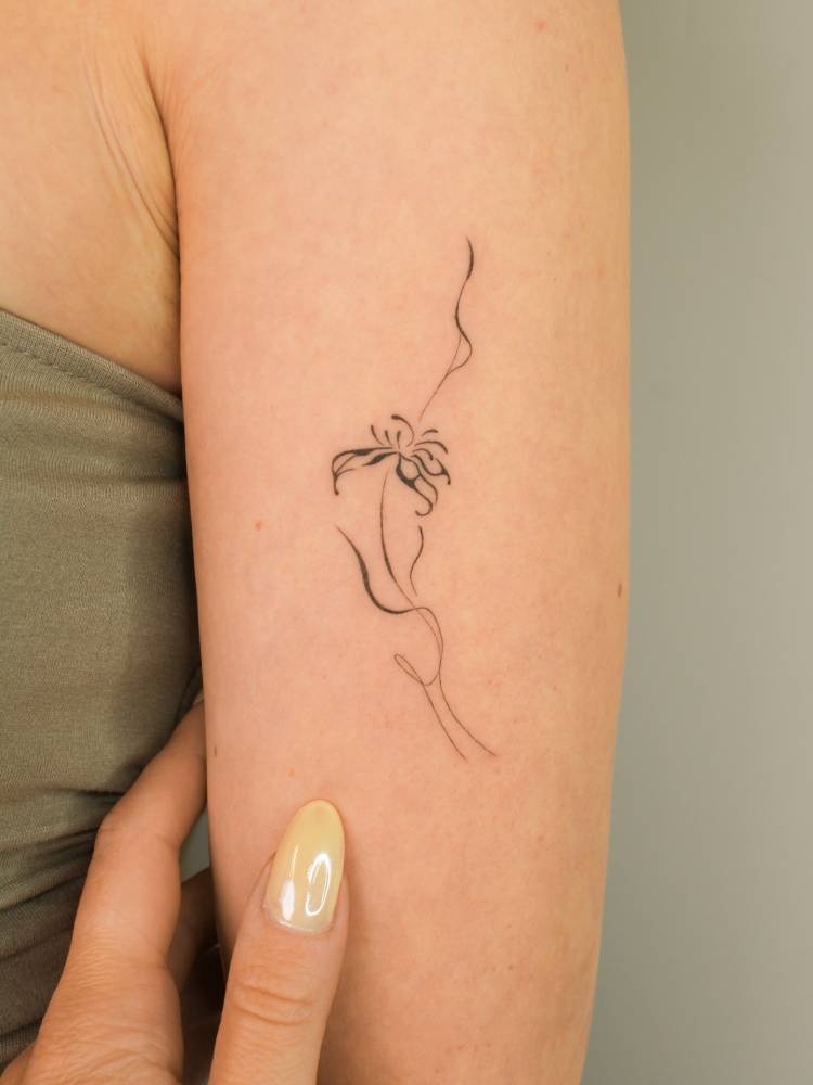 Abstract flower tattoo located on the upper arm.