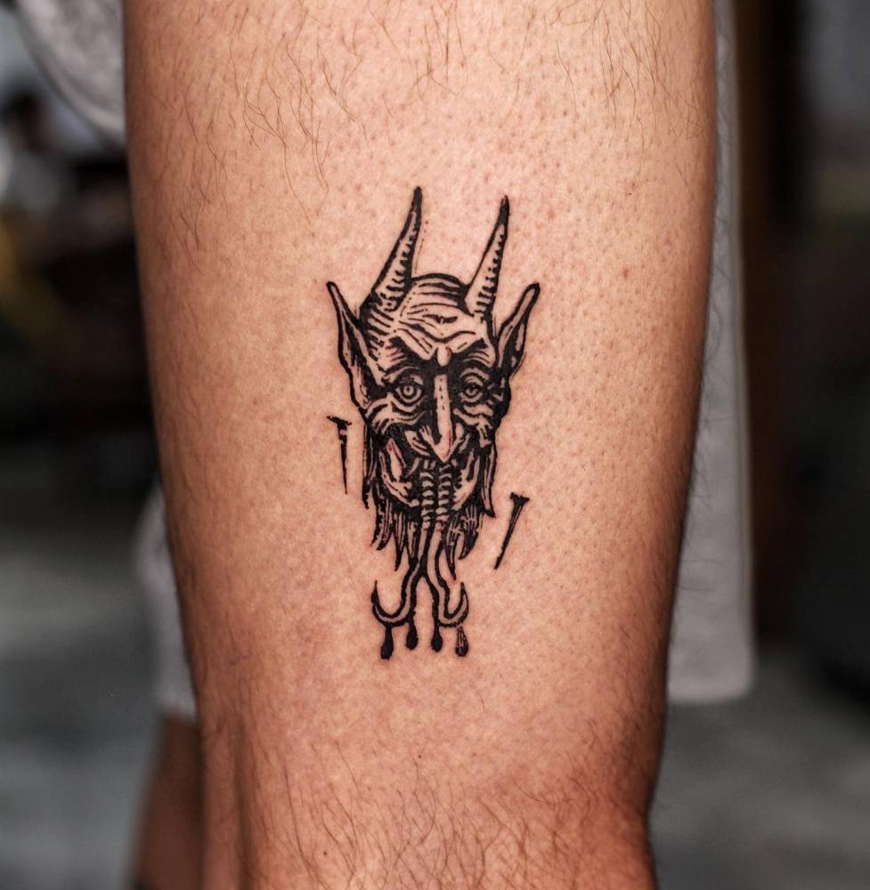 Engraving style devil portrait tattoo placed on the thigh.