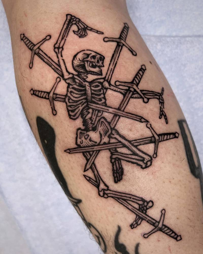 Engraving style dancing skeleton and swords tattoo located on the calf.