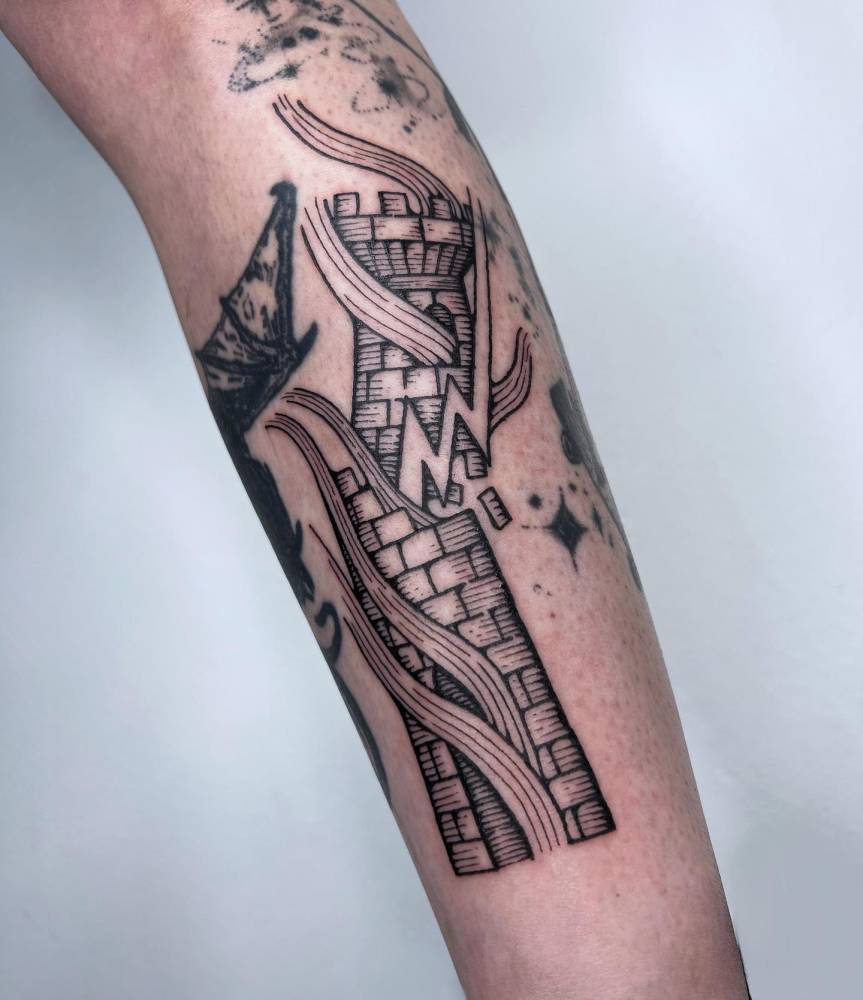 Broken tower tattoo located on the inner forearm, engraving style.