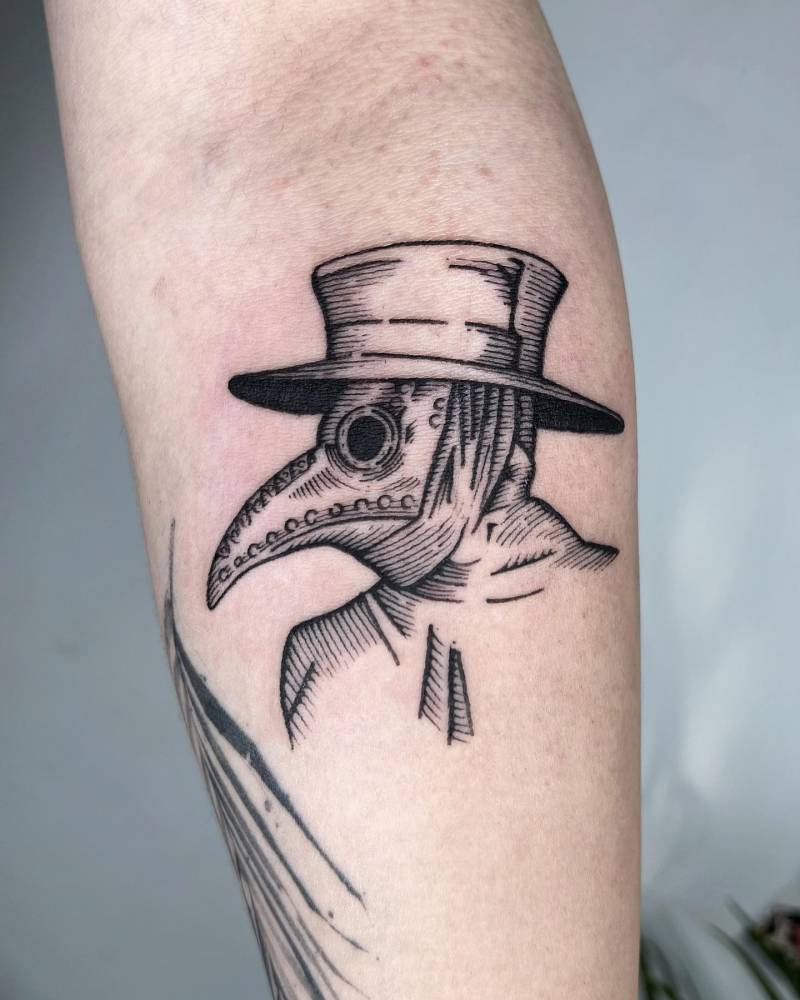 Plague doctor portrait tattoo in engraving style located on the inner forearm.