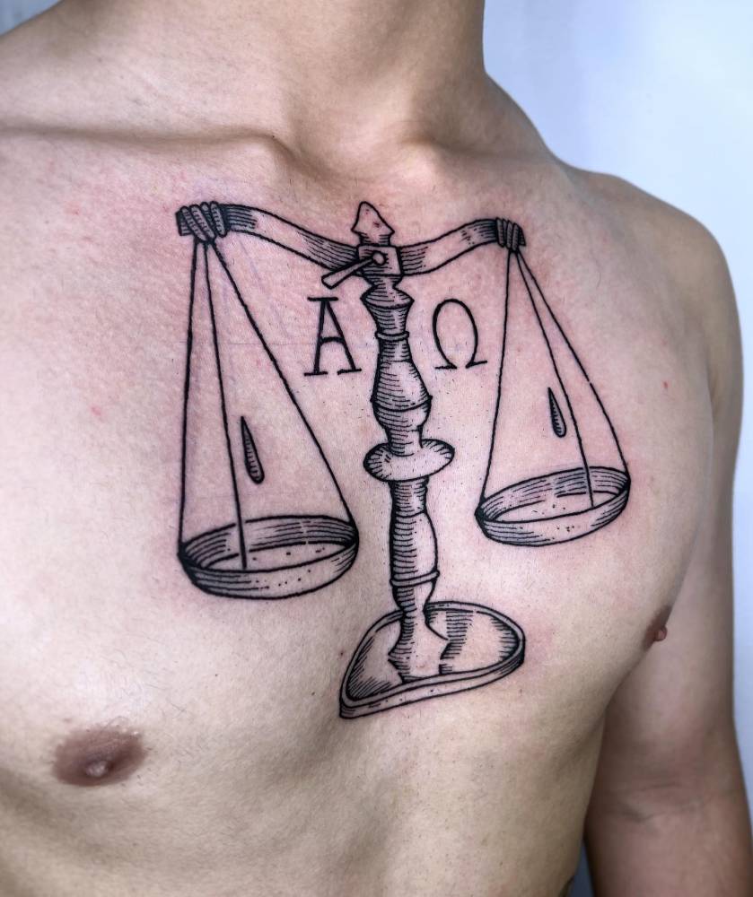 Scale tattoo in engraving style located on the chest.