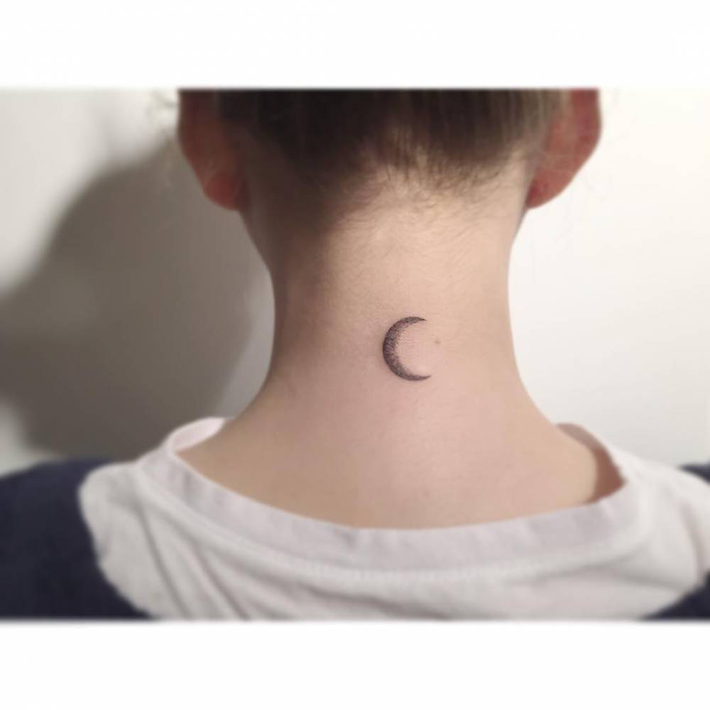 Crescent moon tattoo in illustrative style located on the back of the neck.