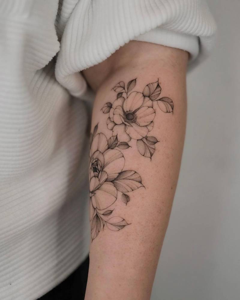 Peonies and anemone tattooed on the forearm.
