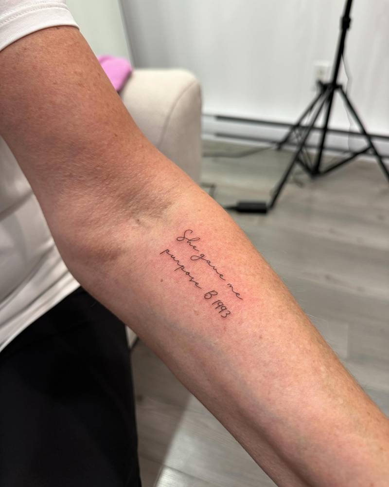"She gave me purpose", butterfly and birth year "1993" tattooed on the inner forearm.