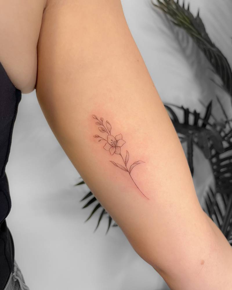 Flower tattoo located on the inner arm, done in fine line style.