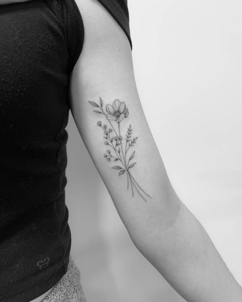 Illustrative style flower bouquet tattoo located on the inner arm.