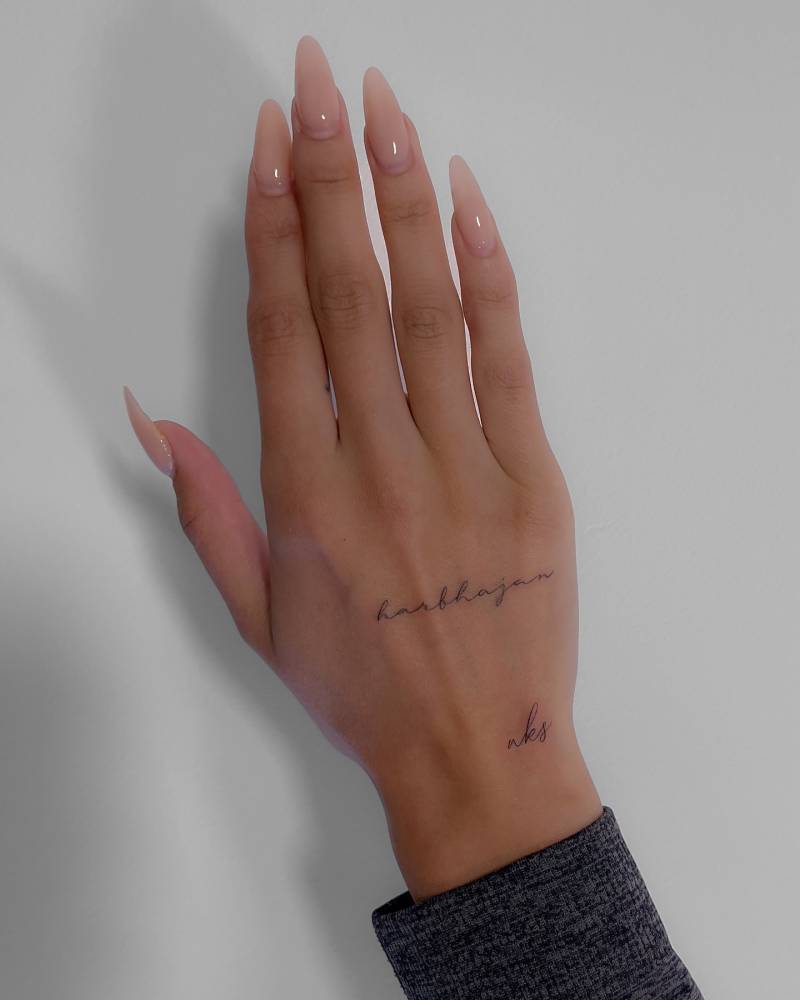 Handwritten font name "Harbhajan" tattooed on the hand.