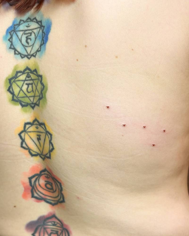 Freckle hearts tattoo located on the back.