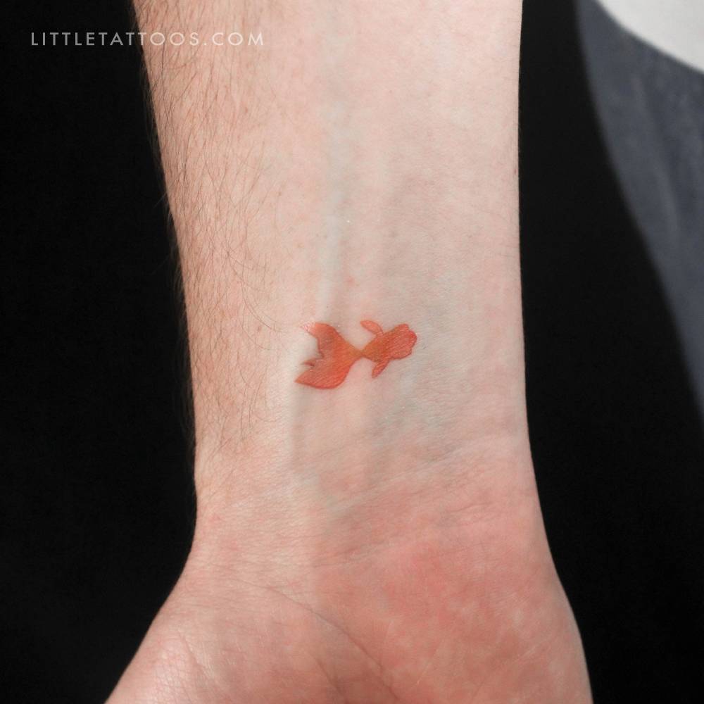 Watercolor style telescope goldfish temporary tattoo located on the wrist.