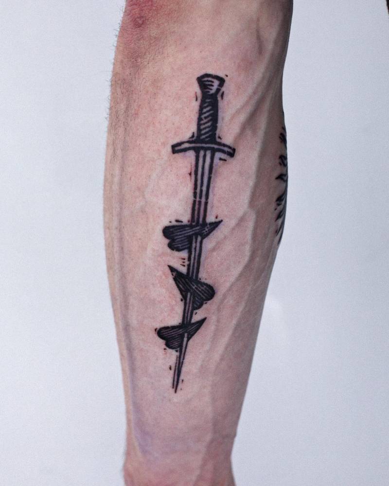 Heart and dagger tattoo in blackwork style located on the inner forearm.
