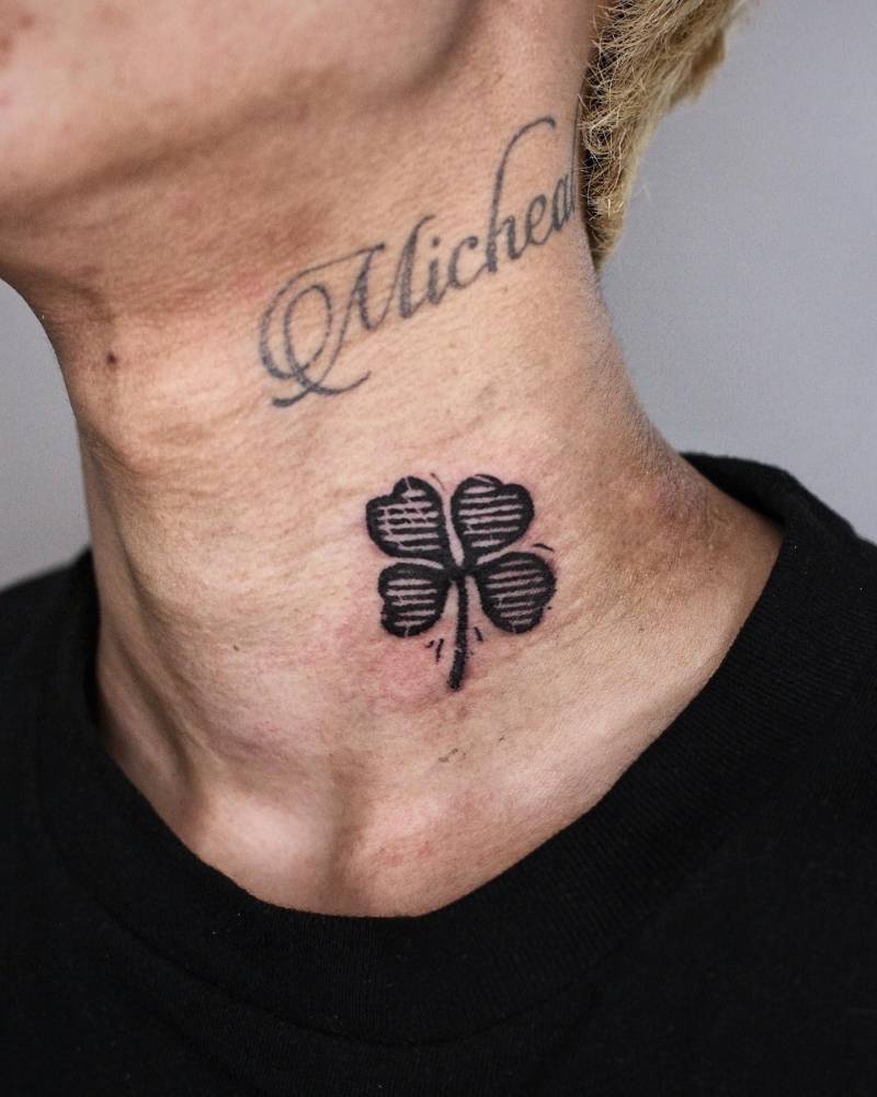 Four leaf clover tattoo in blackwork style placed on the neck.