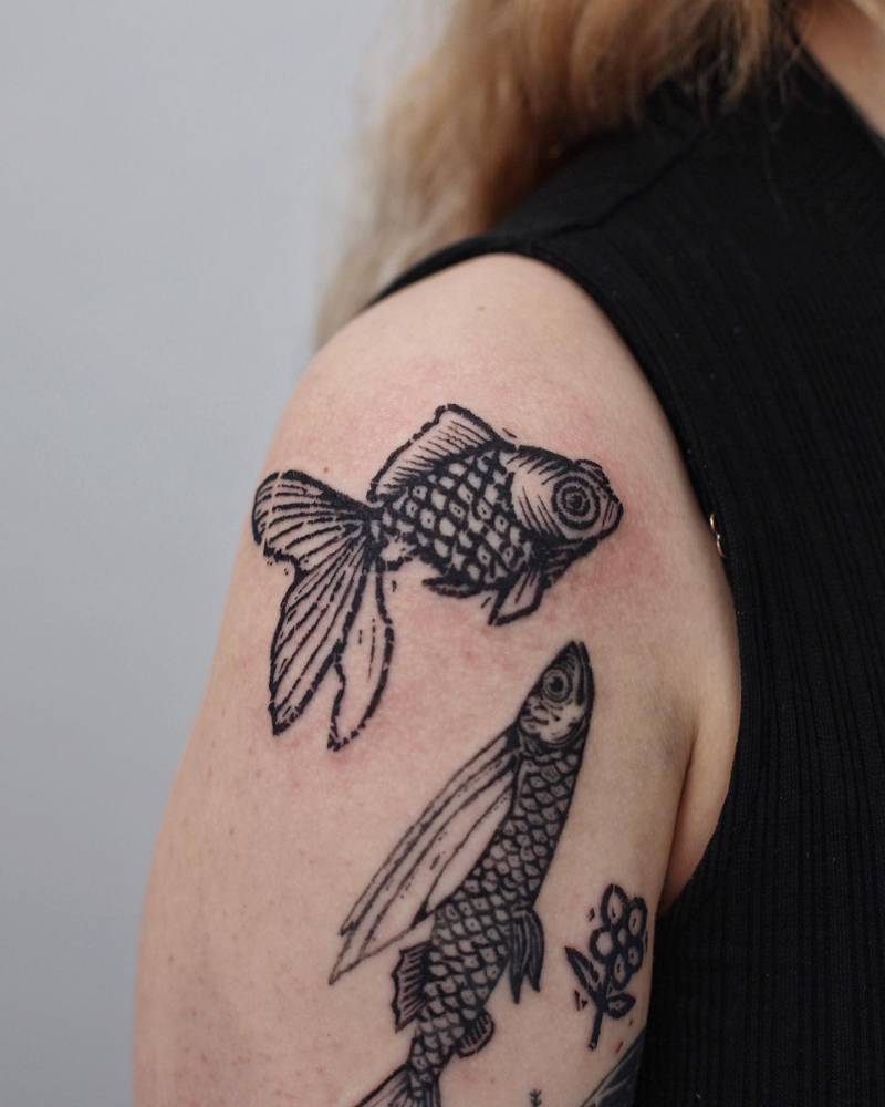 Goldfish tattoo in engraving style located on the shoulder.