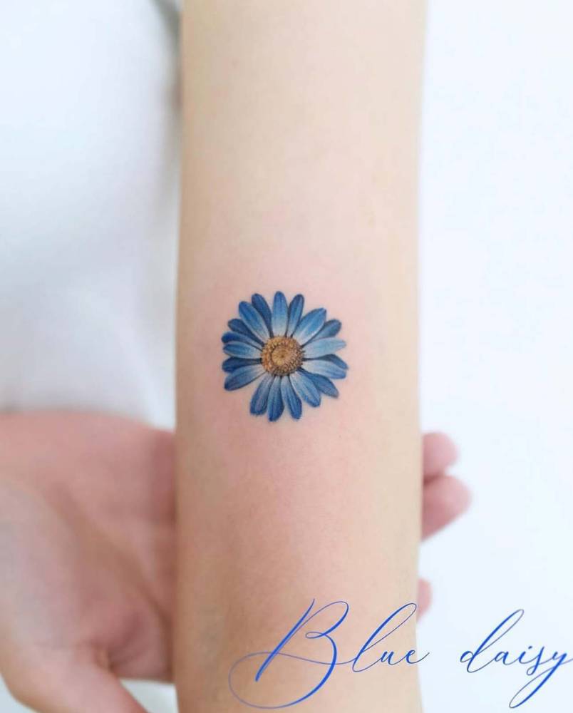 Micro-realistic style daisy tattoo done on the upper arm.