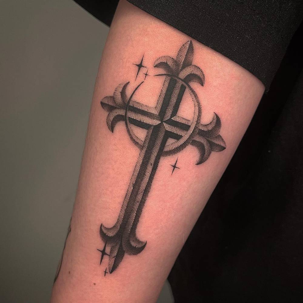 Dotwork style cross and crescent moon tattoo located on the forearm.